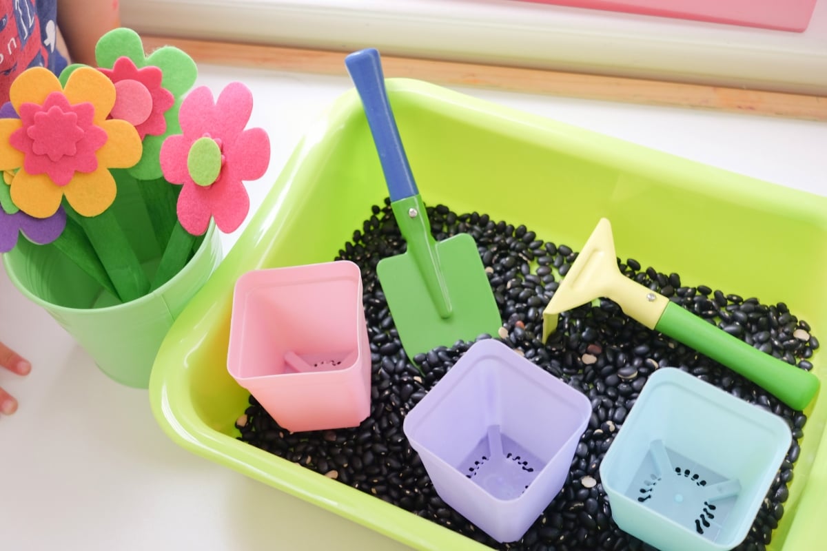 Garden sensory bin with shovels and beans