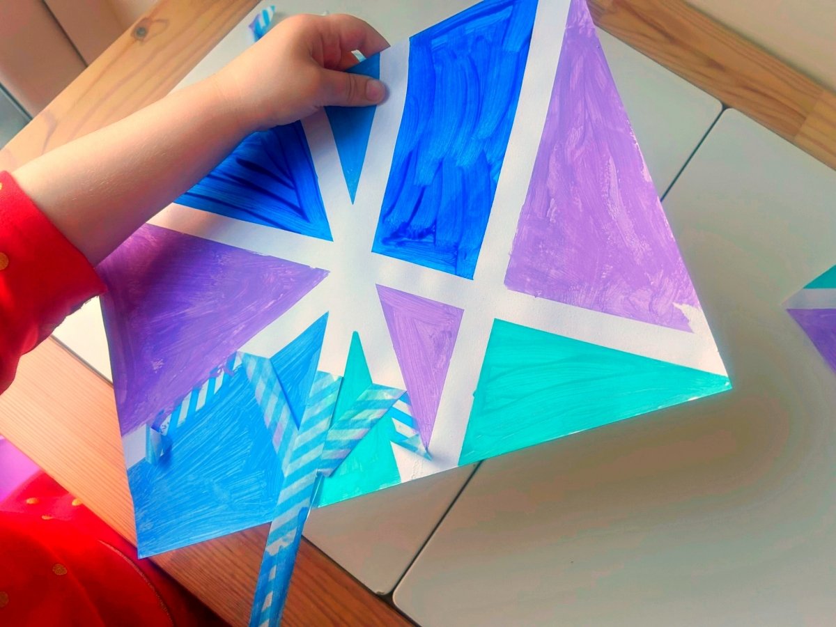 removing washi tape to reveal white lines of the geometric painting