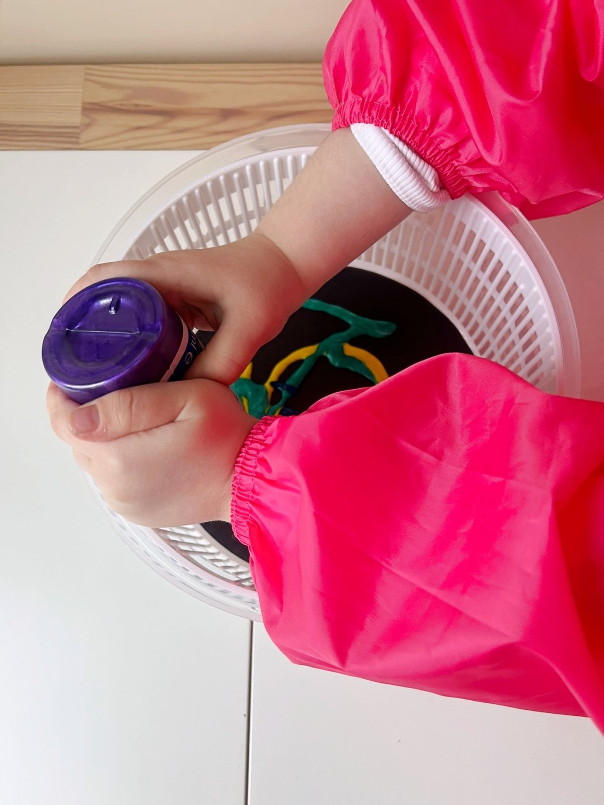 squeeze paint onto cardstock paper inside a salad spinner
